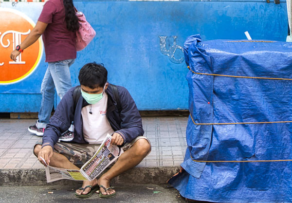 newspaper reading on sidewalk