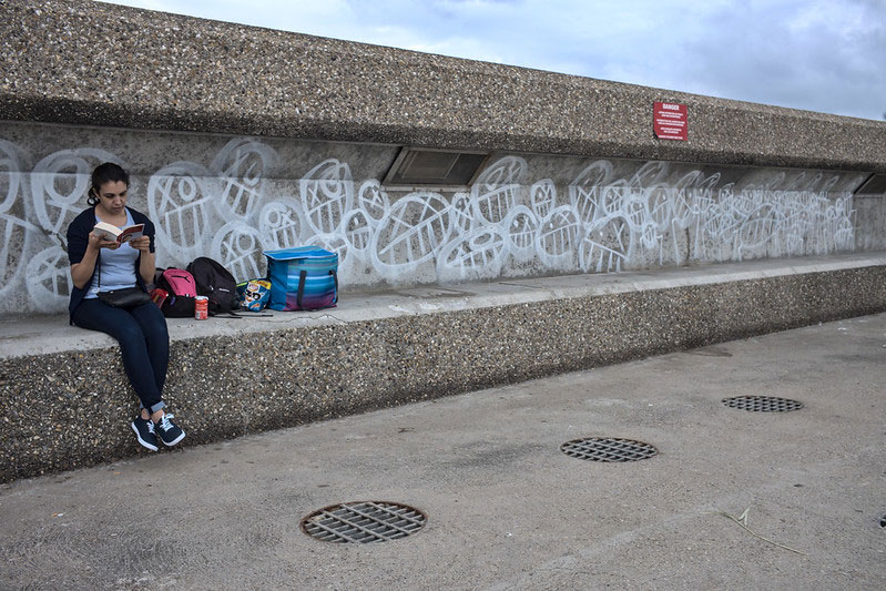 woman reading on concrete bench